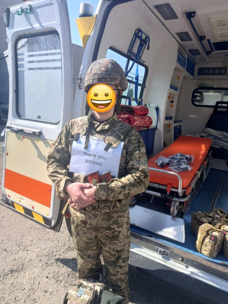 A serviceman in front of a newly delivered ambulance, thanking supporters for life-saving equipment.